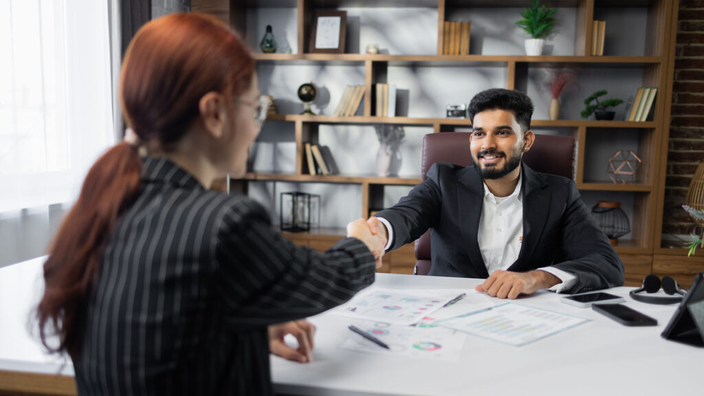 Happy caucasian female job seeker shake hand of smiling male hr manager being accepted on vacant place.