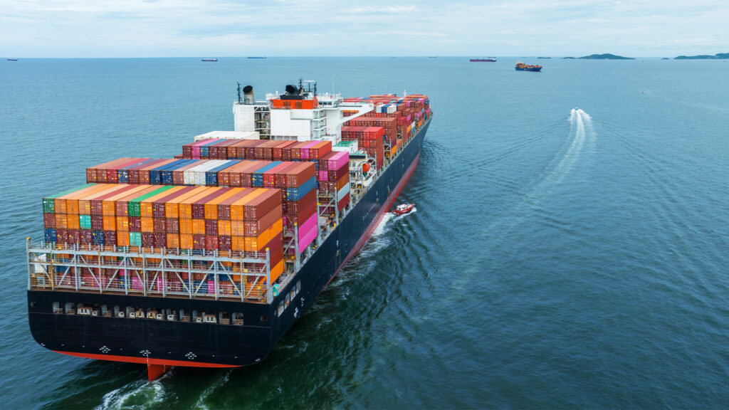 Aerial Stern view of cargo container ship carrying container from custom container depot go to ocean