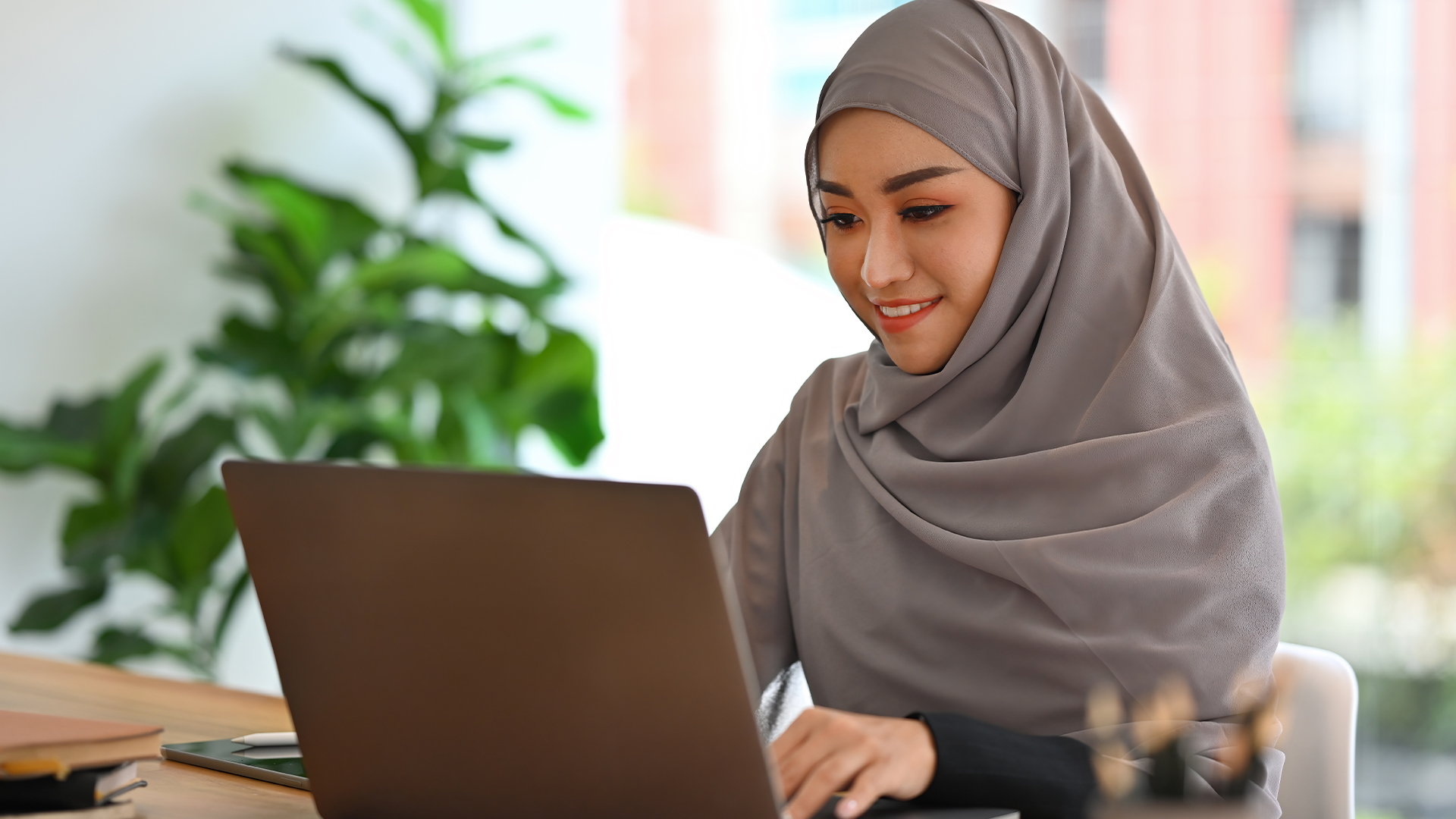 Young Muslim Businesswoman with hijab working with laptop and doing financial report.