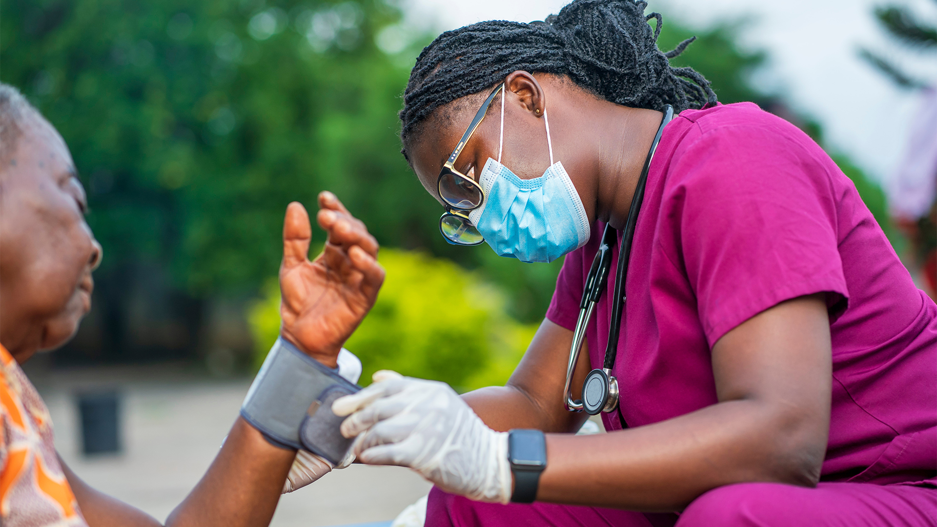 image of health worker checking up blood pressure outside - personal support worker assisting patients in home service in Ghana
